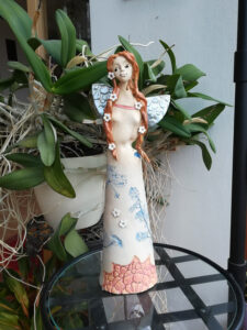 keramická víla stojící, s květinovým motivem na šatech s dlouhými copy